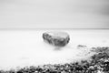 Romantic atmosphere in peaceful morning at sea. Big boulders sticking out from smooth wavy sea. Pink horizon Royalty Free Stock Photo