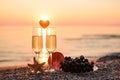 Romantic atmosphere at sunset by the sea. Heart between glasses against the background of the sun. Royalty Free Stock Photo