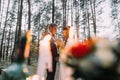 Romantic autumn pine forest picknick with candles. Happy newlyweds celebrating their marriage