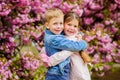 Romantic babies. Couple kids walk sakura tree garden. Tender love feelings. Little girl and boy. Romantic date. Spring