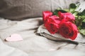 Romantic background with copy space. Beautiful roses and paper hearts. Selective focus