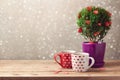 Romantic background with cup of tea and tree plant with hearts on wooden table. Valentine's day concept