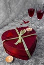 Romantic background. Valentine`s day celebration by lovers. Two glasses of red wine, heart shaped gift box with yellow ribbon, Royalty Free Stock Photo