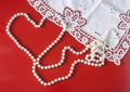 Romantic background for valentine`s day with pearl necklace in the shape of a heart and lace on red background Royalty Free Stock Photo