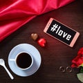 Romantic background with wedding ring, rose flowers, smartphone, cup of coffee and chocolate candy. Hashtag love Royalty Free Stock Photo