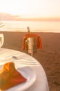 Romantic beach dinner setup with champagne at sunset on sandy shore Royalty Free Stock Photo
