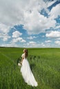 Romantic beautiful bride on sunny summer day outdoors. Young blonde woman in a beautiful wedding dress is running across Royalty Free Stock Photo