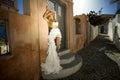 Romantic beautiful bride in white dress posing on terrace with sea and mountains in background in Santorini island, Greece Royalty Free Stock Photo