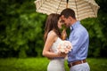 Romantic beautiful couple hugging under elegant umbrella outdoor