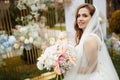 Romantic and beautiful woman in white wedding dress holding a big fresh bouquet of pink and white flowers in her hands Royalty Free Stock Photo