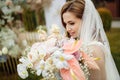 Romantic and beautiful woman in white wedding dress holding a big fresh bouquet of pink and white flowers in her hands Royalty Free Stock Photo