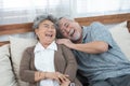 Romantic with big smile and laughing of senior elder asian grandmother and grandfather sit on couch sofa in home,retirement elder