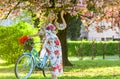 Romantic bike ride. Girl long dress retro cruiser bicycle sakura tree. Spring holidays. Tourism concept. Transportation Royalty Free Stock Photo