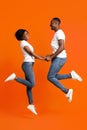 Romantic black couple in love holding hands and jumping up Royalty Free Stock Photo