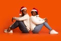 Romantic Black Couple In Santa Hats Sitting And Turning At Each Other