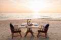 Romantic breakfast on beach. Breakfast table with island sunrise Royalty Free Stock Photo