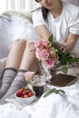 Romantic breakfast in bed. A bouquet of roses and a fragrant morning coffee. Fresh strawberries. Good morning, in the crumpled bed Royalty Free Stock Photo