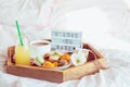 Romantic Breakfast in bed with I love you baby text on lighted box. Cup of coffee, juice, macaroons, flower and gift box on wooden Royalty Free Stock Photo