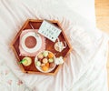 Romantic Breakfast in bed with I love you baby text on lighted box. Cup of coffee, juice, macaroons, flower and gift box on wooden Royalty Free Stock Photo
