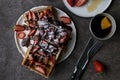 Breakfast with Belgium waffles with strawberry and chocolate at dark background. Concept of lifestyle