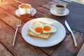 Romantic breakfast for couple. Toast with scrambled eggs in the shape of a heart on a white plate and two cups of coffee Royalty Free Stock Photo