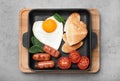 Romantic breakfast with fried sausages, heart shaped egg and toasts on grey table, top view. Valentine`s day celebration Royalty Free Stock Photo