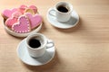 Romantic breakfast with heart shaped cookies and cups of coffee on wooden table Royalty Free Stock Photo