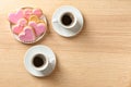 Romantic breakfast with heart shaped cookies and cups of coffee on wooden table, top view. Royalty Free Stock Photo