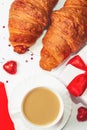 A romantic breakfast for a loved one on Valentine`s Day. Fresh delicious croissants for breakfast with a cup of coffee, chocolate Royalty Free Stock Photo