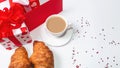 A romantic breakfast for a loved one on Valentine`s Day. Fresh delicious croissants with a cup of coffee, love letter, present on Royalty Free Stock Photo