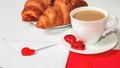 A romantic breakfast for a loved one on Valentine`s Day. Fresh delicious croissants with a cup of coffee, love letter, present on Royalty Free Stock Photo