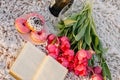 Romantic breakfast on the sandy beach. Photo session on a blanket with tulips and a book, donuts and champagne . Royalty Free Stock Photo