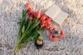 Romantic breakfast on the sandy beach. Photo session on a blanket with tulips and a book, donuts and champagne . Royalty Free Stock Photo