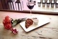 Romantic breakfast, Valentine`s Day celebrating. Present box, rose flowers, fresh croissant, wine on wooden table. Focus on flower Royalty Free Stock Photo