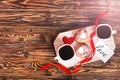 Romantic breakfast for Valentine`s Day. Two cups of coffee, two cupcakes in the form of a heart on a white board on a wooden tabl