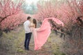 Romantic bridegroom kissing bride on forehead while standing against wall covered with pink flowers Royalty Free Stock Photo