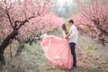 Romantic bridegroom kissing bride on forehead while standing against wall covered with pink flowers Royalty Free Stock Photo