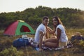 Romantic camping. A young couple sitting by the bonfire