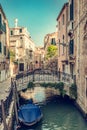 Romantic canal in Venice, Italy with scenic bridge and boat
