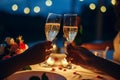 Romantic candlelight dinner for couple table setup at night. Man and Woman hold glass of Champaign.