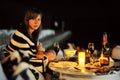 Romantic candlelit dinner by the sea at night. Beautiful young girl at the table Royalty Free Stock Photo