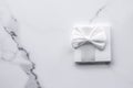 Luxury wedding gifts with silk bow and ribbons on marble background Royalty Free Stock Photo