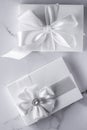 Luxury wedding gifts with silk bow and ribbons on marble background Royalty Free Stock Photo