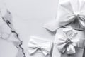 Luxury wedding gifts with silk bow and ribbons on marble background Royalty Free Stock Photo