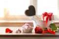 Romantic celebration with gift rose and jelly beans on table