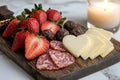 Romantic charcuterie board with cheese, salami, strawberries, and chocolate. Royalty Free Stock Photo