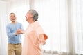Romantic and cheerful Asian well-being senior couple enjoy dancing and holding hands to music together with smiles and happiness Royalty Free Stock Photo