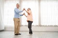 Romantic and cheerful Asian well-being senior couple enjoy dancing and holding hands to music together with smiles and happiness Royalty Free Stock Photo