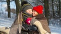 Little girl kissing boy with gift outdoors.