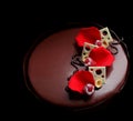 Romantic chocolate raspberry cake with rose petals, white chocolate decorations and fresh berries on black background Royalty Free Stock Photo